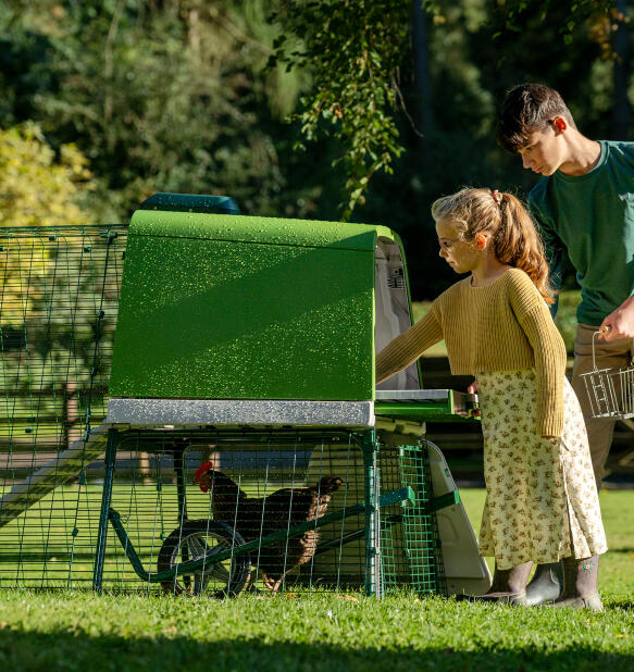 brother and sister collecting eggs from teh easy access elevated chicken coop